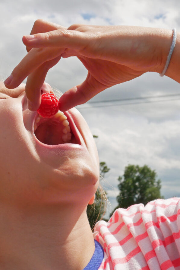 A customer tasting a raspberry